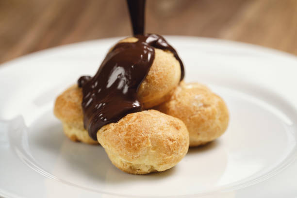 istock pour chocolate on profiteroles on plate closeup 1509200698
