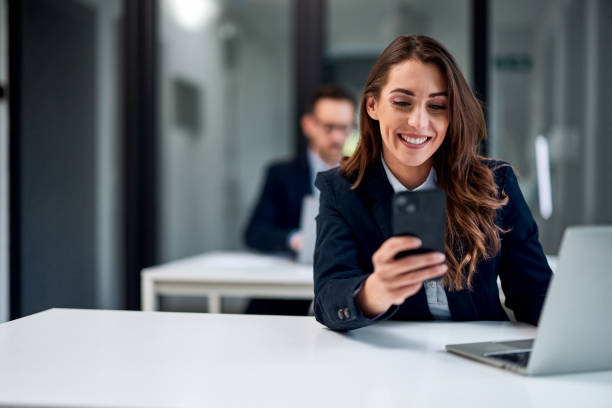istock A smiling female bank employee using a mobile phone while working over a laptop. 1509221678