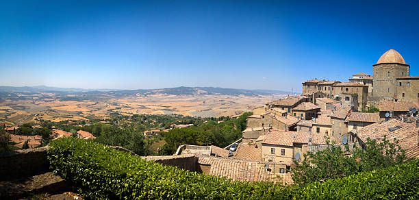 Drone shot of dramatic landscape and medieval old town against cloudy sky during sunny day in Todi, Umbria, Italy