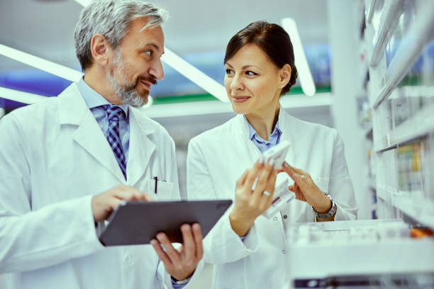 istock A female and male pharmacist looking at each other while doing inventory. 1509244628