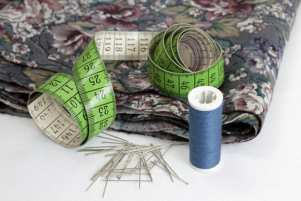 Reel of cotton, pins, fabric and a measuring tape stock photo