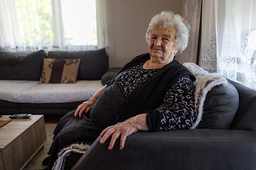 Senior woman having a faint smile as she tries to cope with being alone