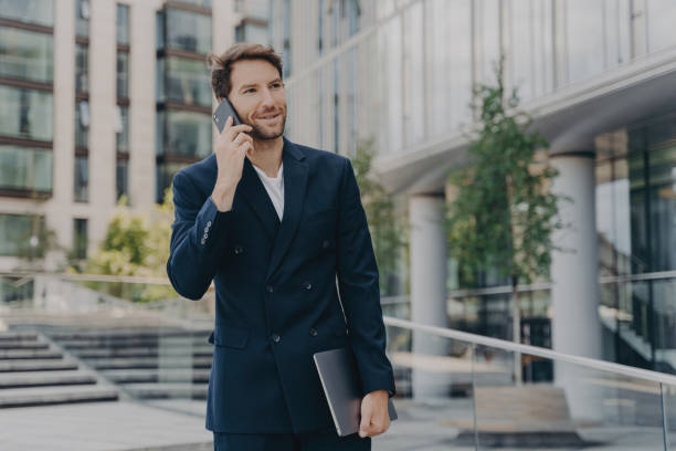 istock Handsome entrepreneur communicates, uses tech, dressed formal, poses outdoor, solves company issues, collaborates with colleagues 1509270289