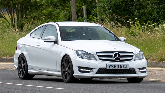 Milton Keynes,UK - July 2nd 2023.  2014 MERCEDES-BENZ C220 AMG SPORT EDT PREM CDI A car travelling on an English country road