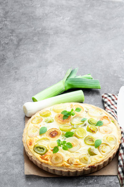 Quiche with leek and cheese on gray background