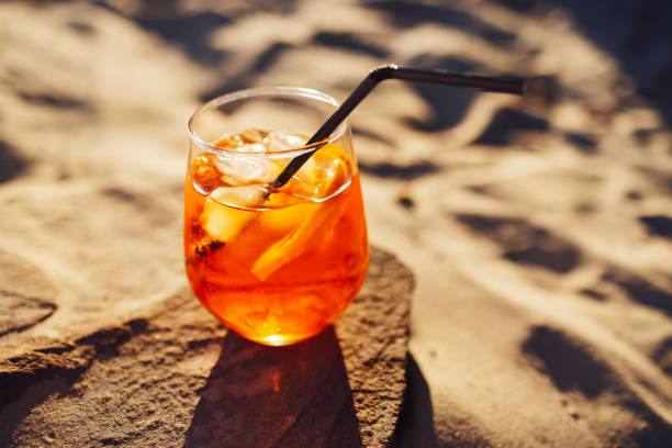 istock Orange slice and Spritz cocktail on a stone against the backdrop of a sandy beach 1509328191