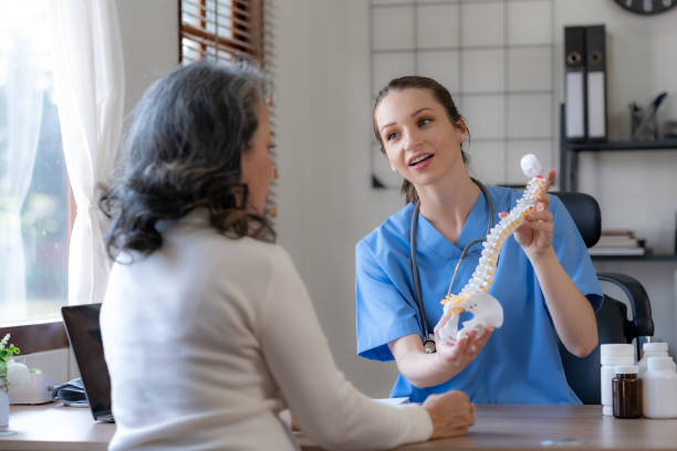 female doctor is introducing an elderly asian female patient about bone diseases and treatment method and medicine details. - healthcare and medicine laboratory senior adult analyzing imagens e fotografias de stock