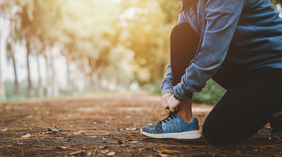 Health and lifestyle concepts, Fitness, Exercising, jogging, running. Asian woman tying her shoes at outdoor park in morning, taking break from exercise.