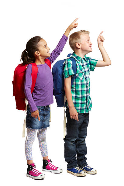 istock 8 year old school boy and girl with backpacks pointing 150938979