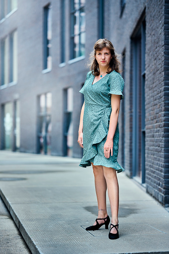 Portraits full length in the cityscape. Young woman looking at camera