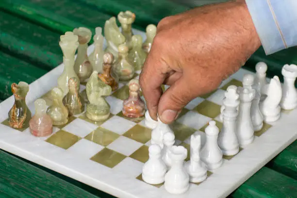 Street chess game. The grandmaster makes a pawn move. Dedicated to International Chess Day.