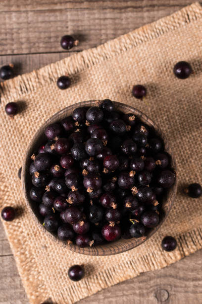 istock Black currant in a bowl on wooden background. Organic berries. 1509485962