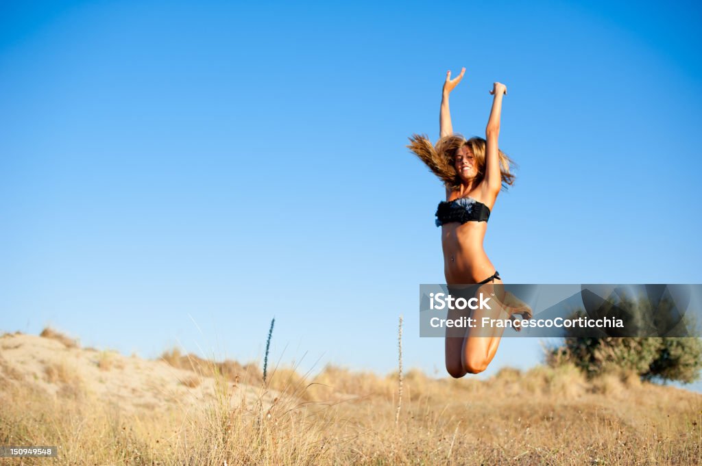 Giovane donna saltando durante l'estate - Foto stock royalty-free di Adolescente