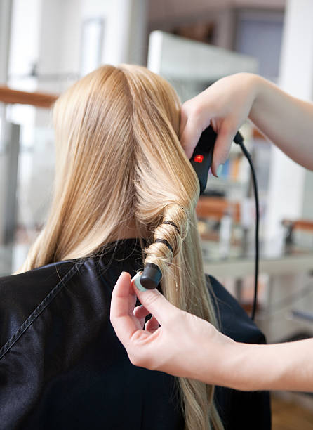 istock Stylist Curling Womans Hair 150950624