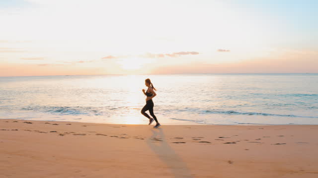 Sport woman running on beach