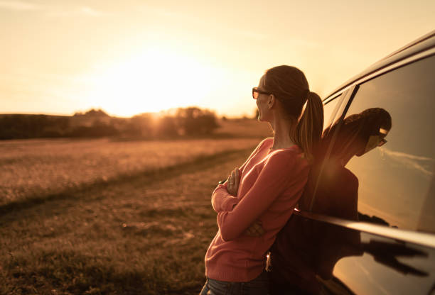 Woman enjoying sunset during road trip.
