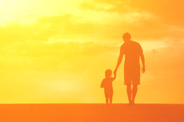 istock Father and son walking in the meadow at sunset. 1509525805