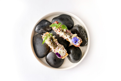 Exquisite serving of fish eclairs with black caviar isolated
