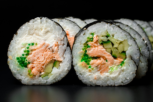 Japanese food. Closeup view on rolls with fish, vegetables and cream cheese wrapped in nori