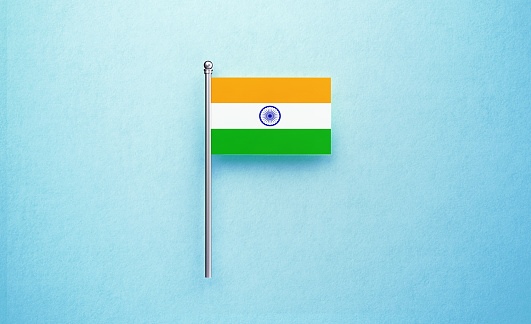 Tiny Indian flag on blue background. Horizontal composition with copy space.