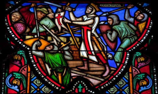 Godfrey of Bouillon (1060 – July 1100) was a medieval Frankish knight who was one of the leaders of the First Crusade from 1096 until his death. This stained glass window in the cathedral of Brussels depicts the Siege of Jerusalem by the Crusaders in the 11th Century. This window was created in 1866, no property release is required.