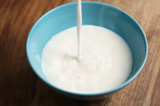 istock fresh milk poured into blue bowl on wood table 1509634143