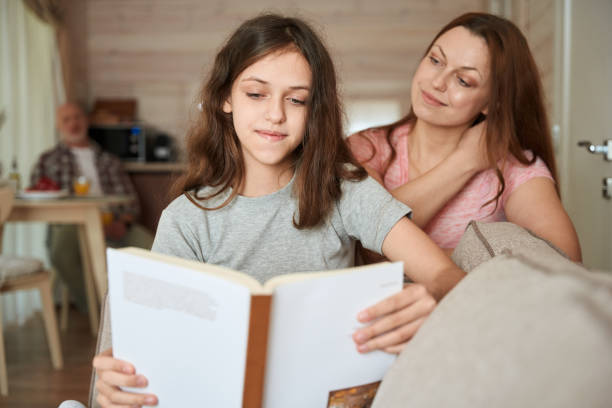 istock Concentrated young lady reading book supervised by female parent 1509660700
