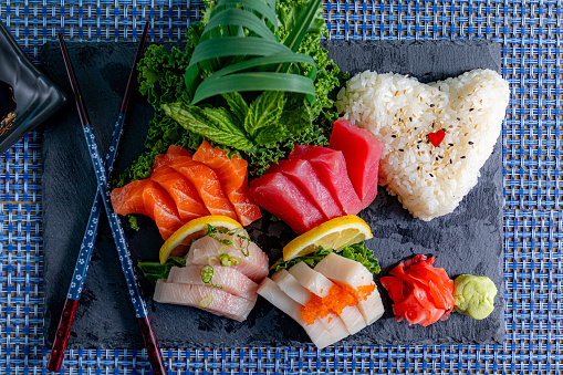 fresh sushis and white wine on a wooden plate isolated on black background
