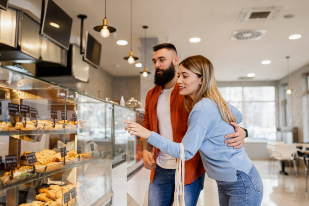istock Beautiful young couple is choosing pastries and smiling while doing shopping at the bakery 1509702838