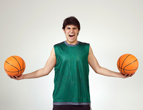 Young sportsman holding basketballs