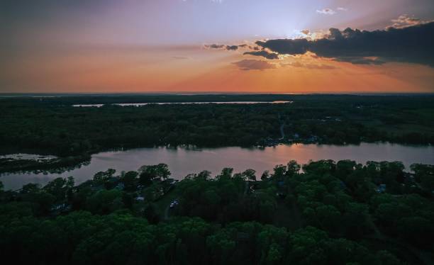istock an image of the sun setting over some trees and a lake 1509720254