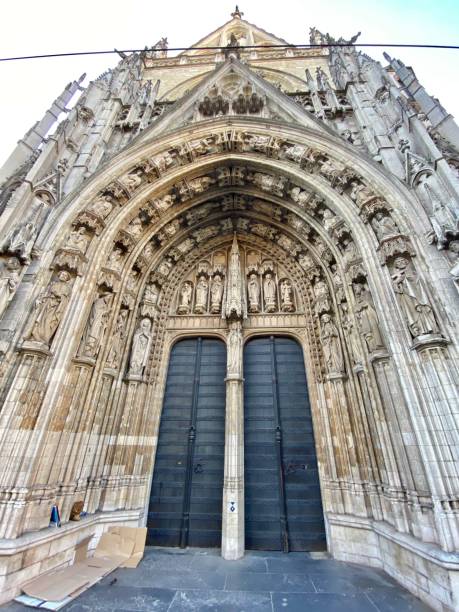 el pórtico occidental de la iglesia de nuestra señora del sablón tiene un tímpano intrincadamente tallado que muestra importantes figuras religiosas. - vísperas solemnes fotografías e imágenes de stock