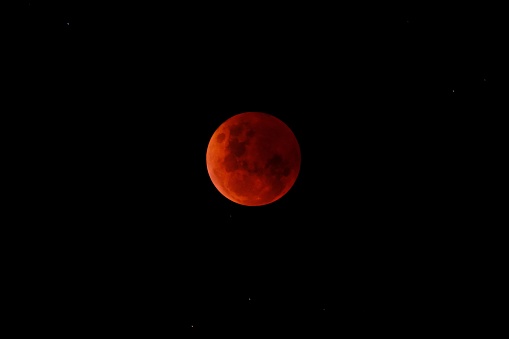 A stunning view  of a deep orange lunar eclipse