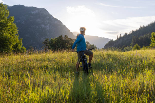 istock Man pauses on mountain bike in meadow 1509834601
