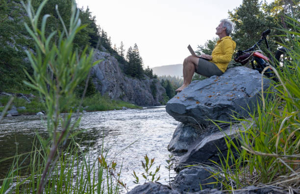 istock Man uses laptop on rock above stream 1509835659