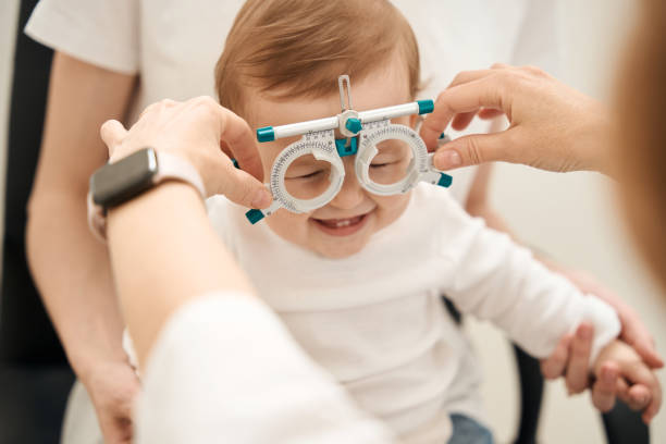 Eye specialist preparing little patient for visual acuity test