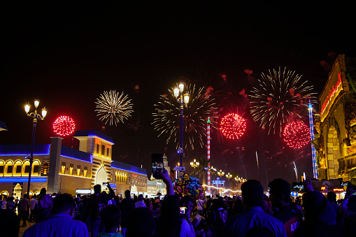 Dubai, United Arab Emirates - December 28, 2017: People enjoying fireworks in Dubai Global village at one of the most visited tourist attractions in the United Arab Emirates at night
