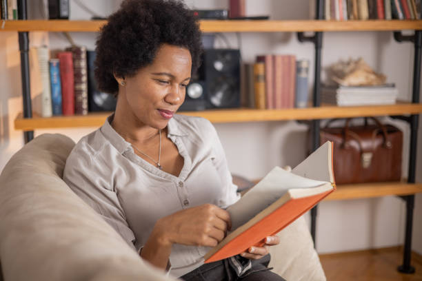 istock Woman reading book at home 1509985806