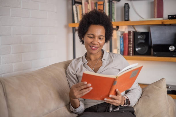 istock Woman reading book at home 1509985808
