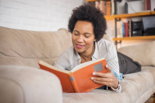 istock Woman reading book at home 1509985867