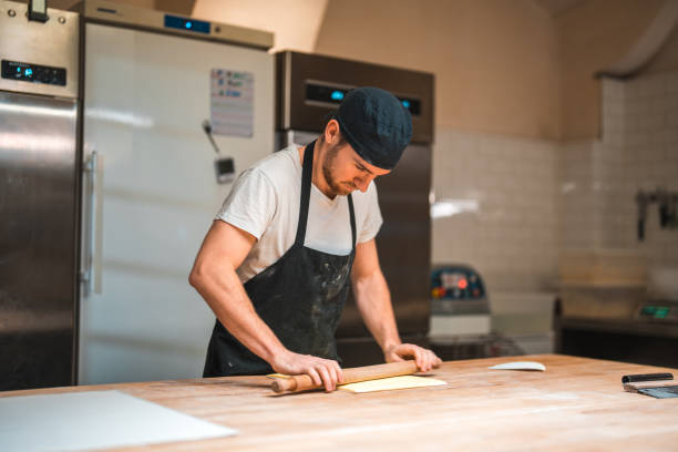 istock Caucasian Baker Rolling Butter Wrapped In A Baking Paper 1509988057