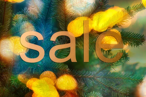 a background picture of festive bokey blurry christmas lights during the holiday season and sale sign