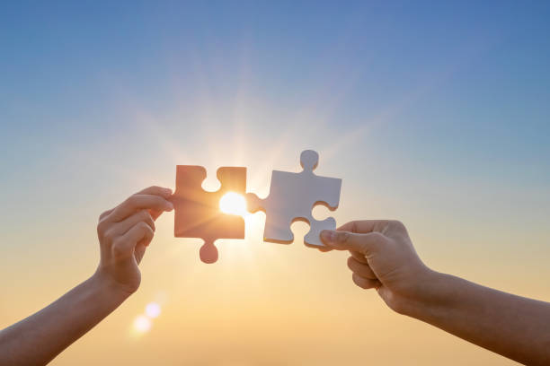 istock Hands holding piece of blank jigsaw puzzle on sunset background.connection concept 1509998099