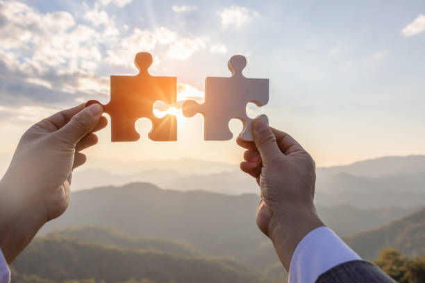 istock Hands holding piece of blank jigsaw puzzle on mountain at sunset background 1510001931