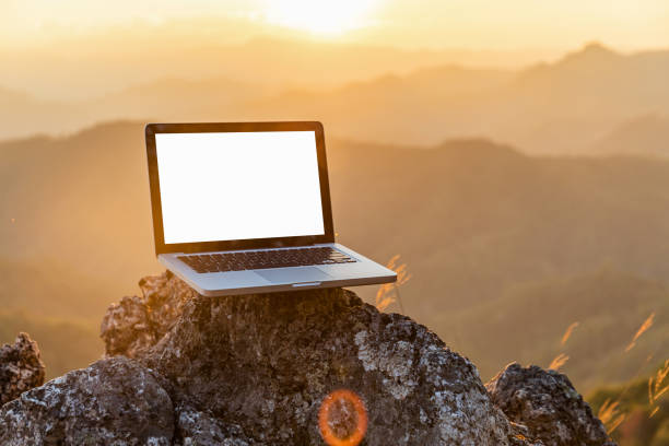 laptop-computer auf sonnenuntergangshintergrund des felsbergs. - mountain scape stock-fotos und bilder