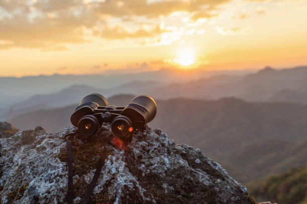 istock binoculars on top of rock mountain at beautiful sunset background. 1510003523
