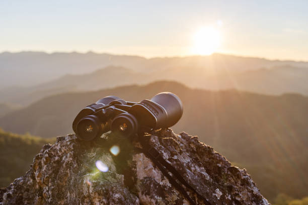 istock binoculars on top of rock mountain at beautiful sunset background. 1510015568