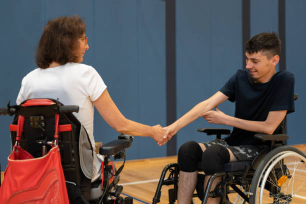 istock Disabled people with dystrophy in a wheelchair shake hands 1510018333