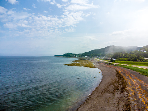 Aerial view of St. Lawrence river beach during summer day in Les Méchins (Gaspesie, Quebec, Canada) with a bit of fog