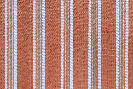 Natural linen texture as background. Cotton fabric with red and white  line striped pattern, texture close up. Backdrop, wallpaper. Matereal for clothes, curtain and upholstery